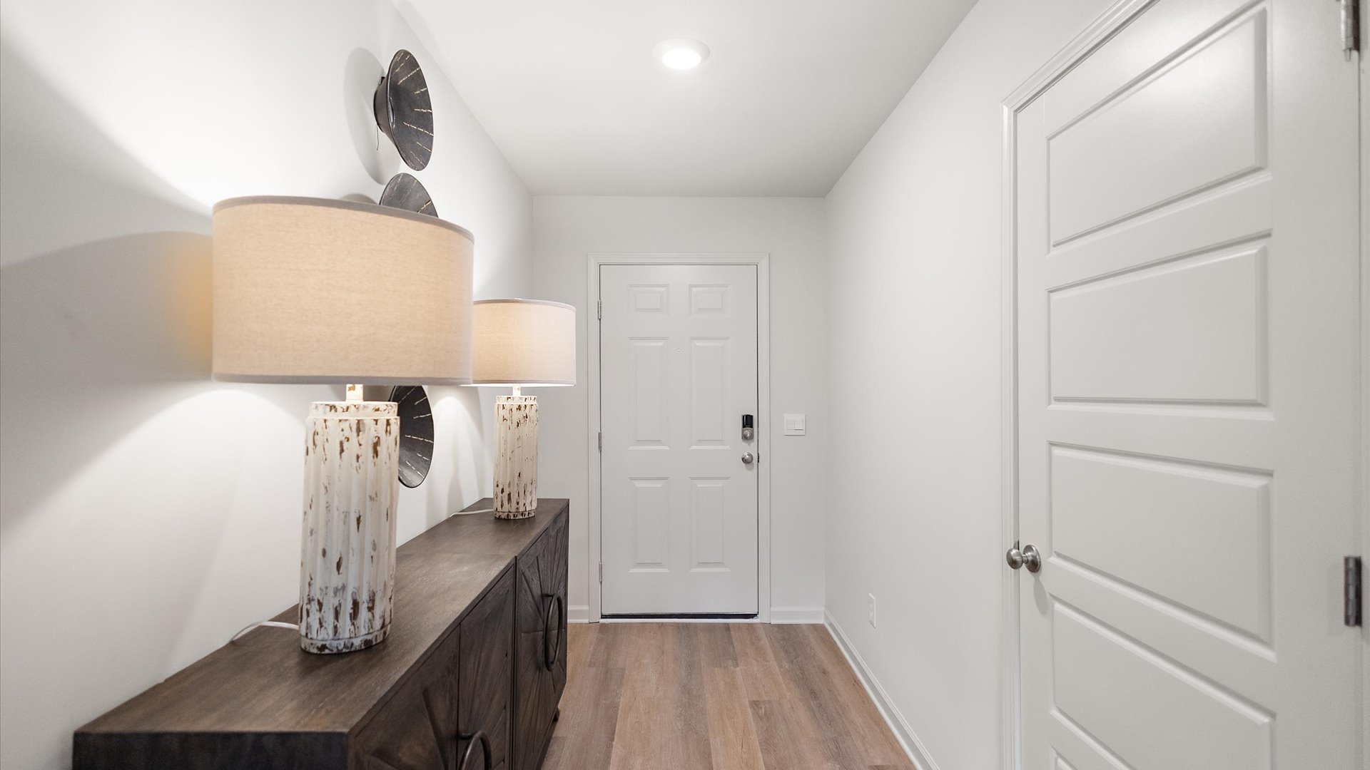 Front entryway and foyer with hardwood floors and door to the garage on the right.