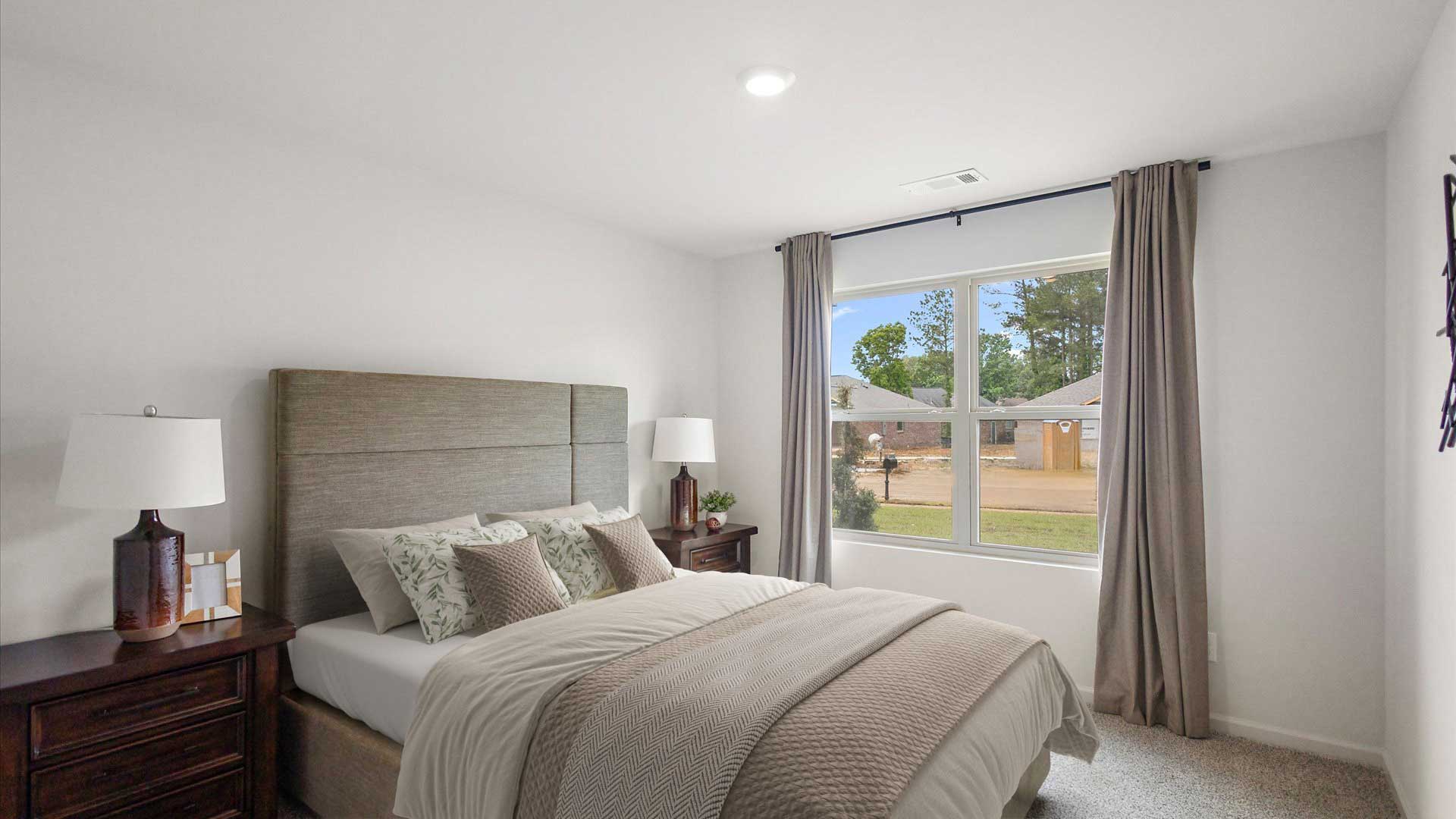 Bedroom four with carpeted floors and windows for natural light.