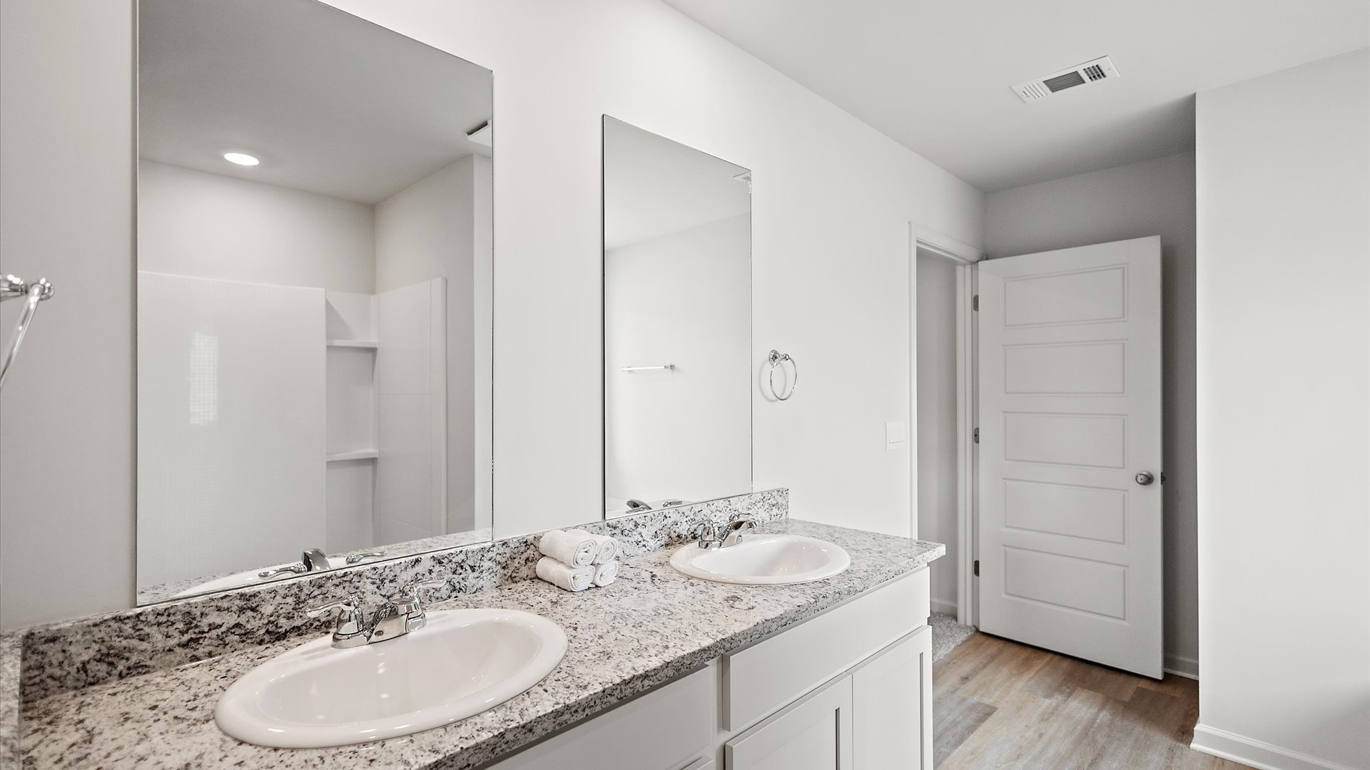 Primary bathroom featuring a double vanity with granite countertops.