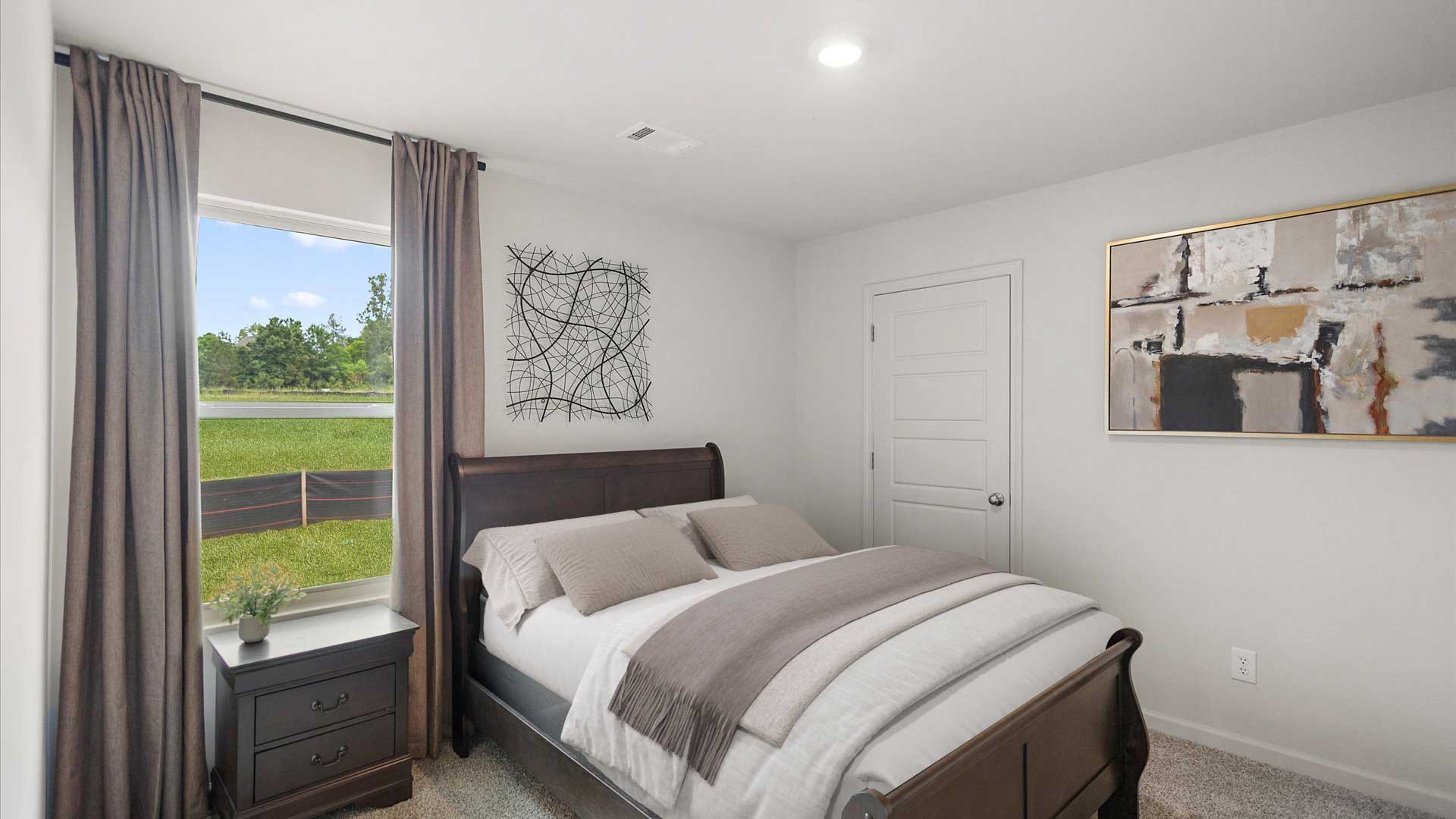 Bedroom two with carpeted floors and windows for natural light.