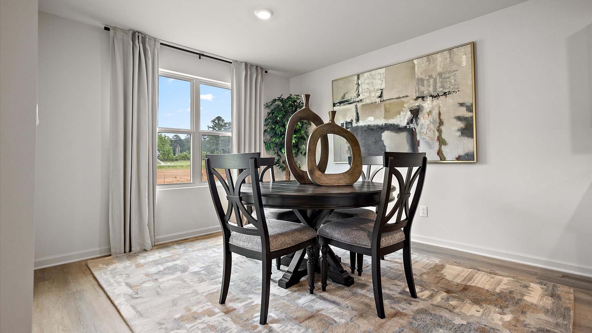 The dining area with hardwood floors with large windows for natural lighting.