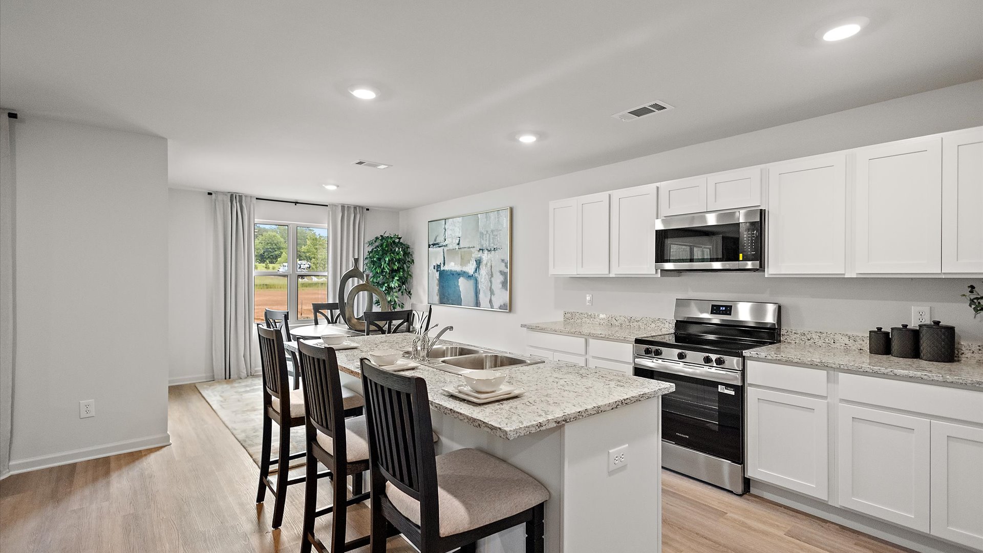 Open concept kitchen with dining area behind.