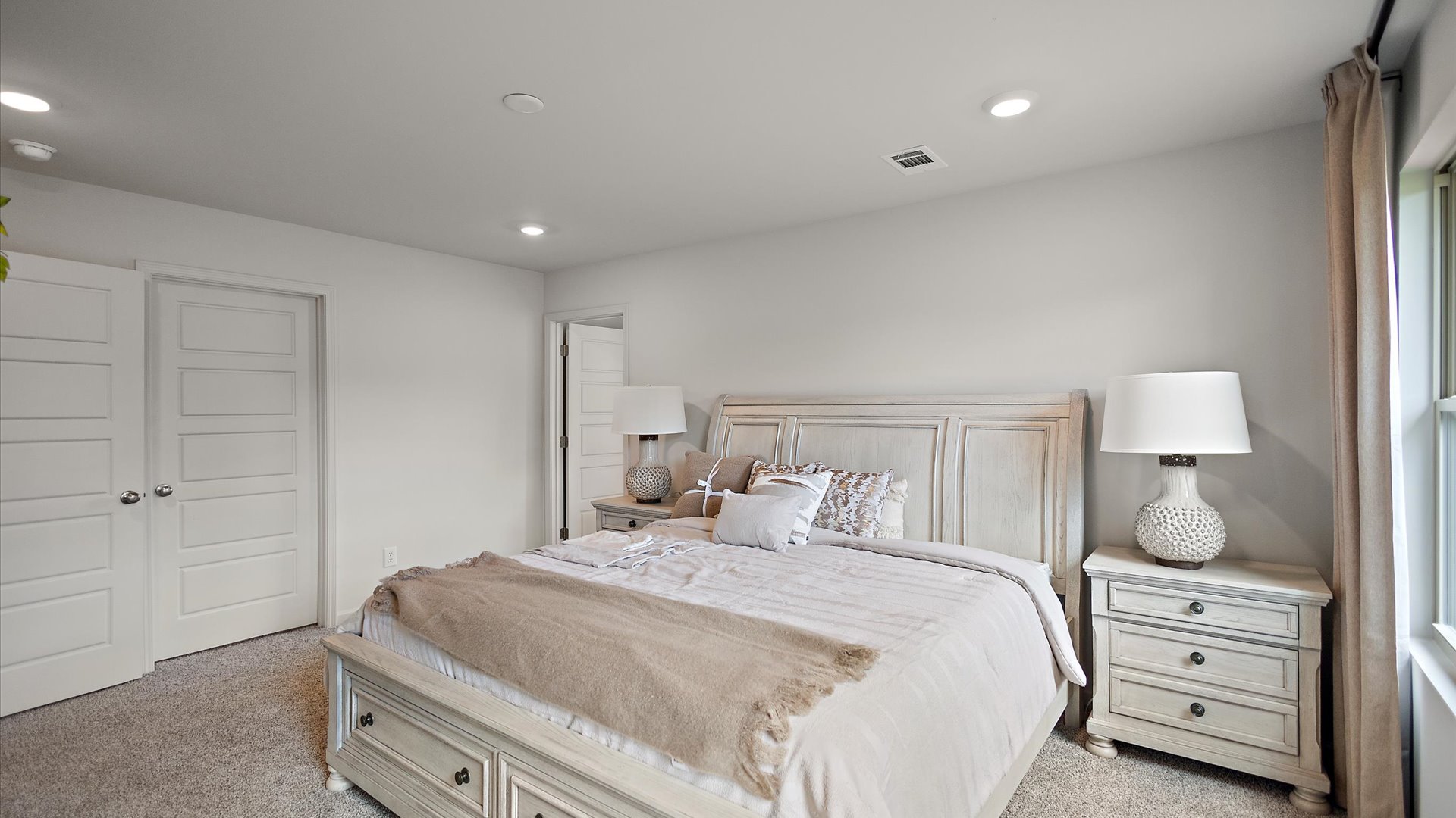 Primary bedroom with large window on the right wall and the clset on the left wall.