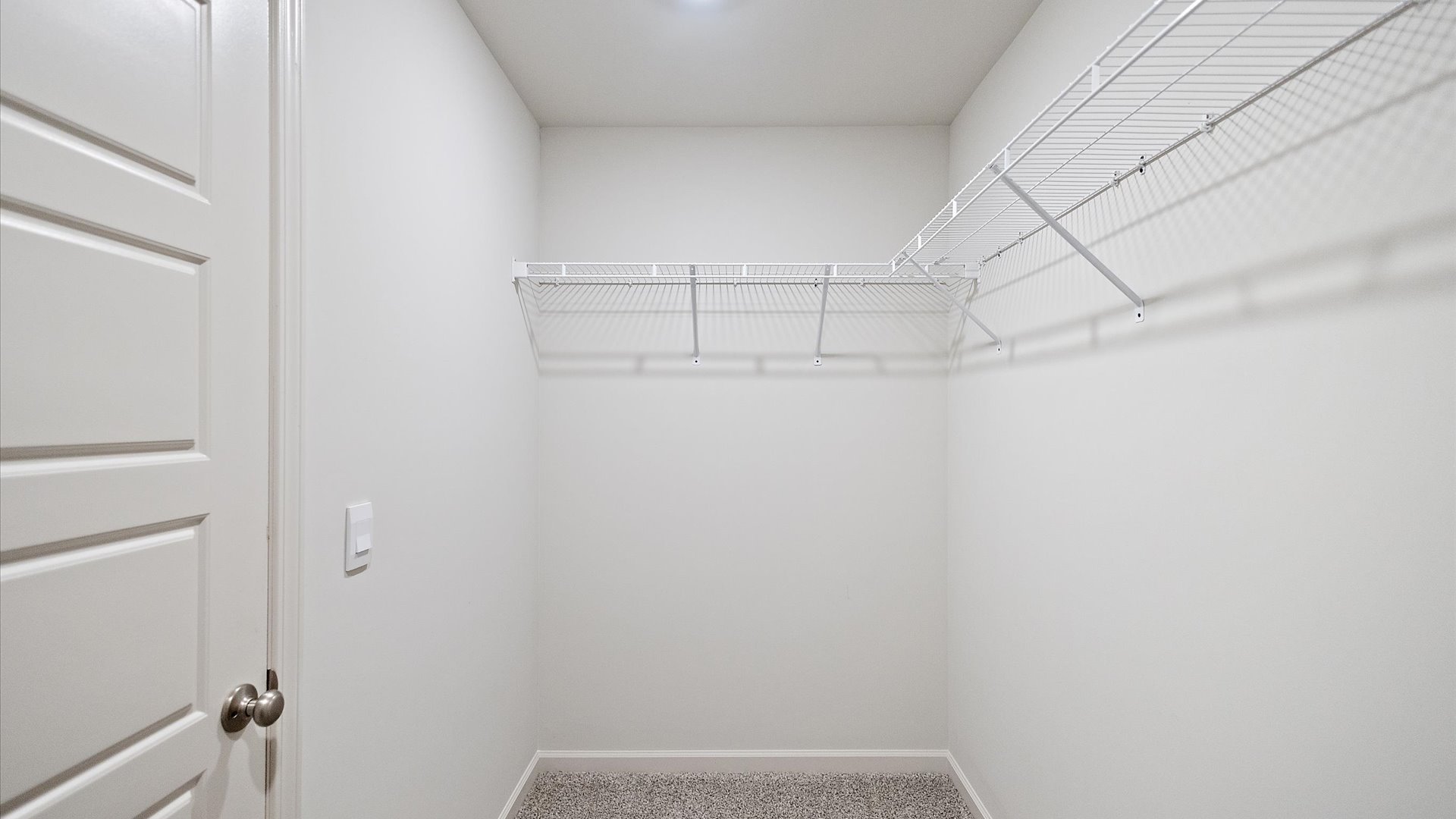 Spacious walk in closet with shelving.