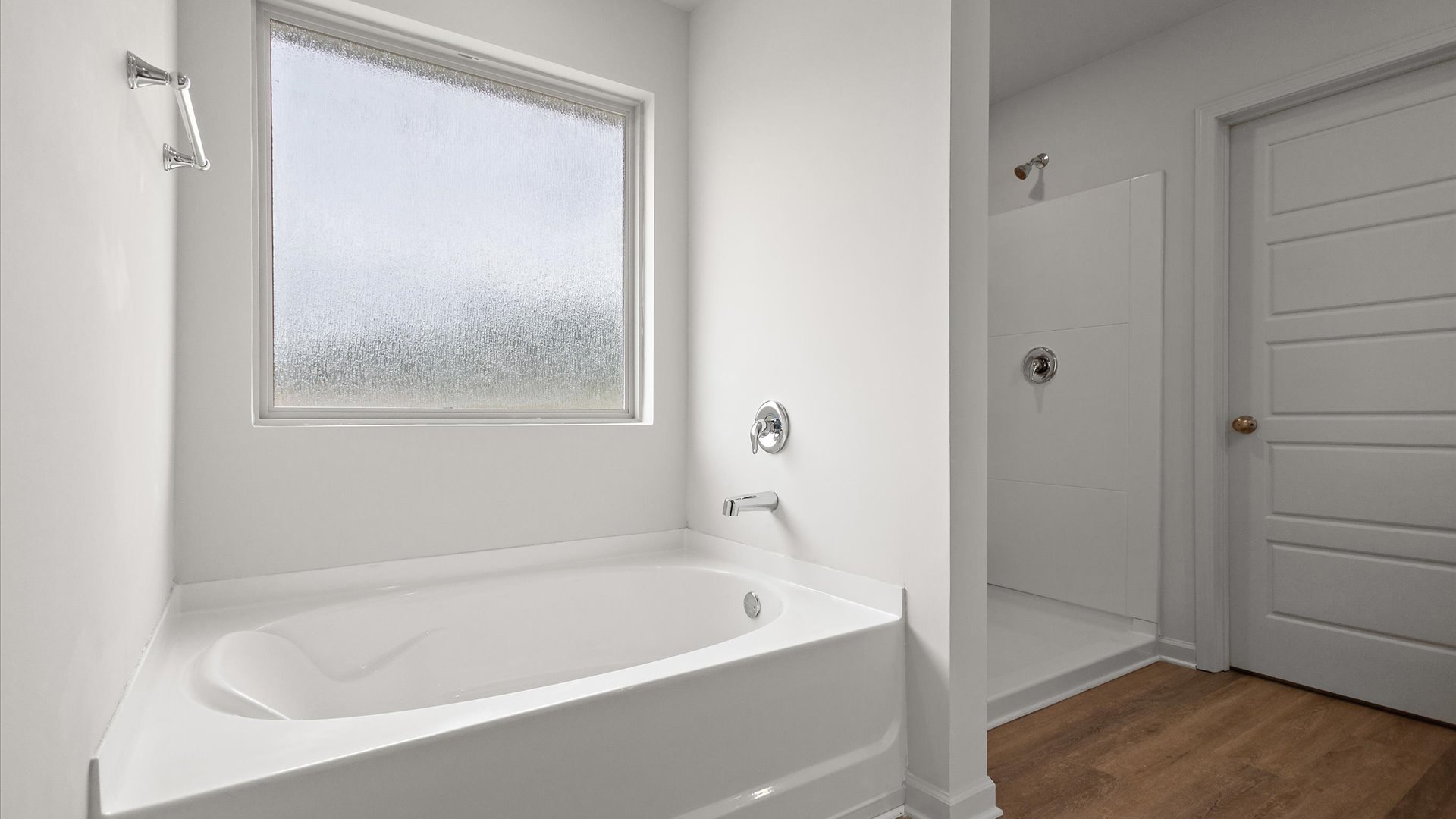 Garden tub with walk in shower on the other side of the wall. Window above the tub for natural light.