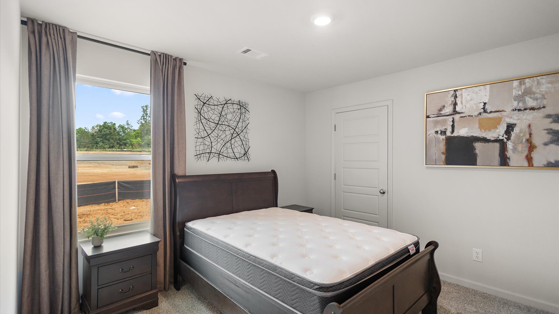 Bedroom two with carpeted floors and windows for natural light.
