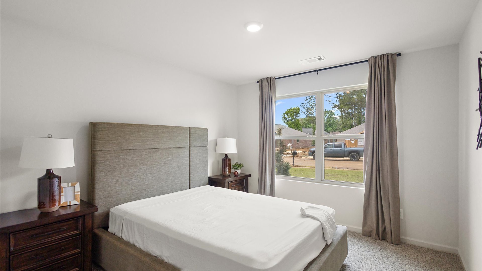 Bedroom four with carpeted floors and windows for natural light.