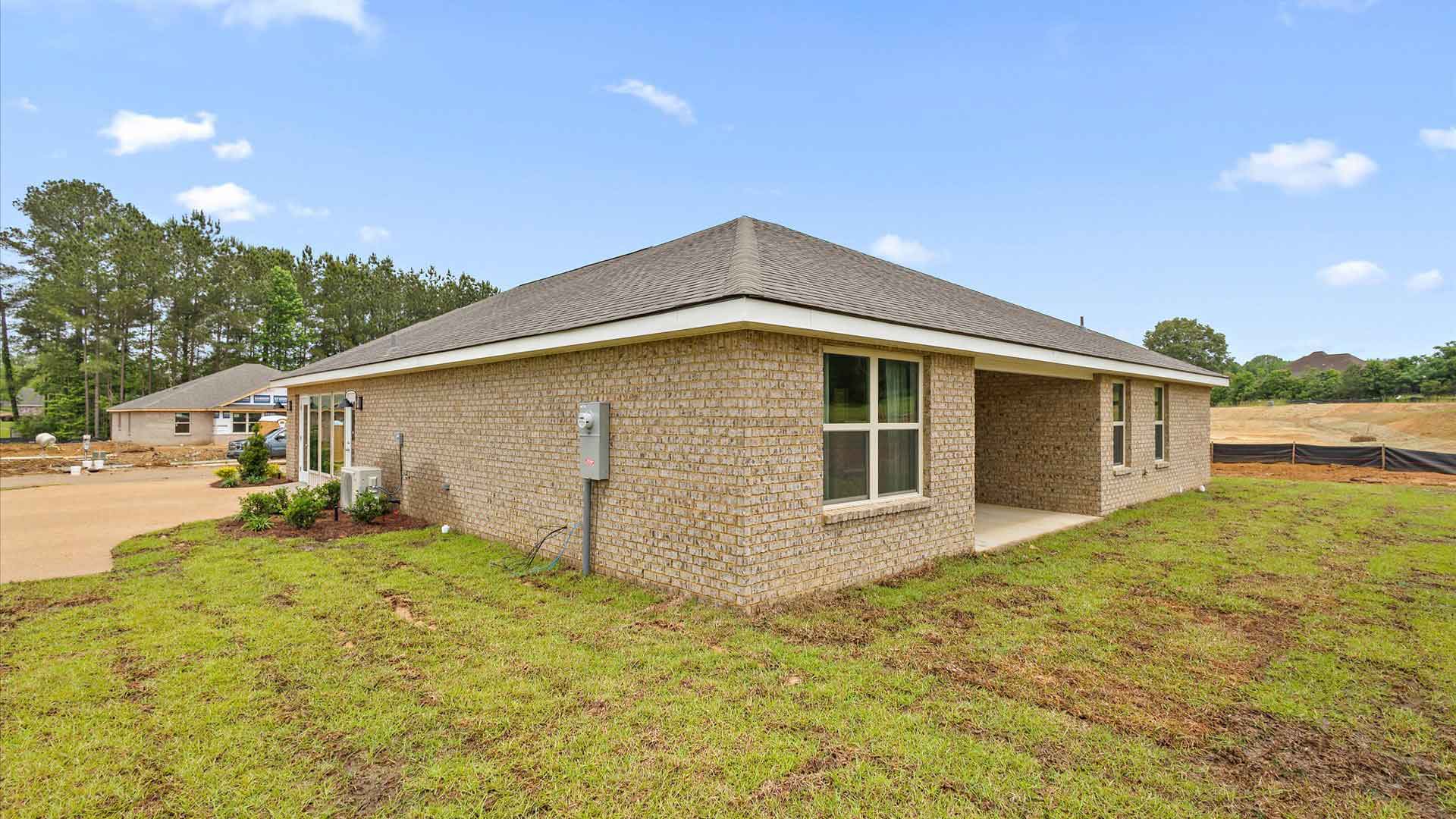 Back side exterior of the covered patio and other side of the house where the drive way is located.