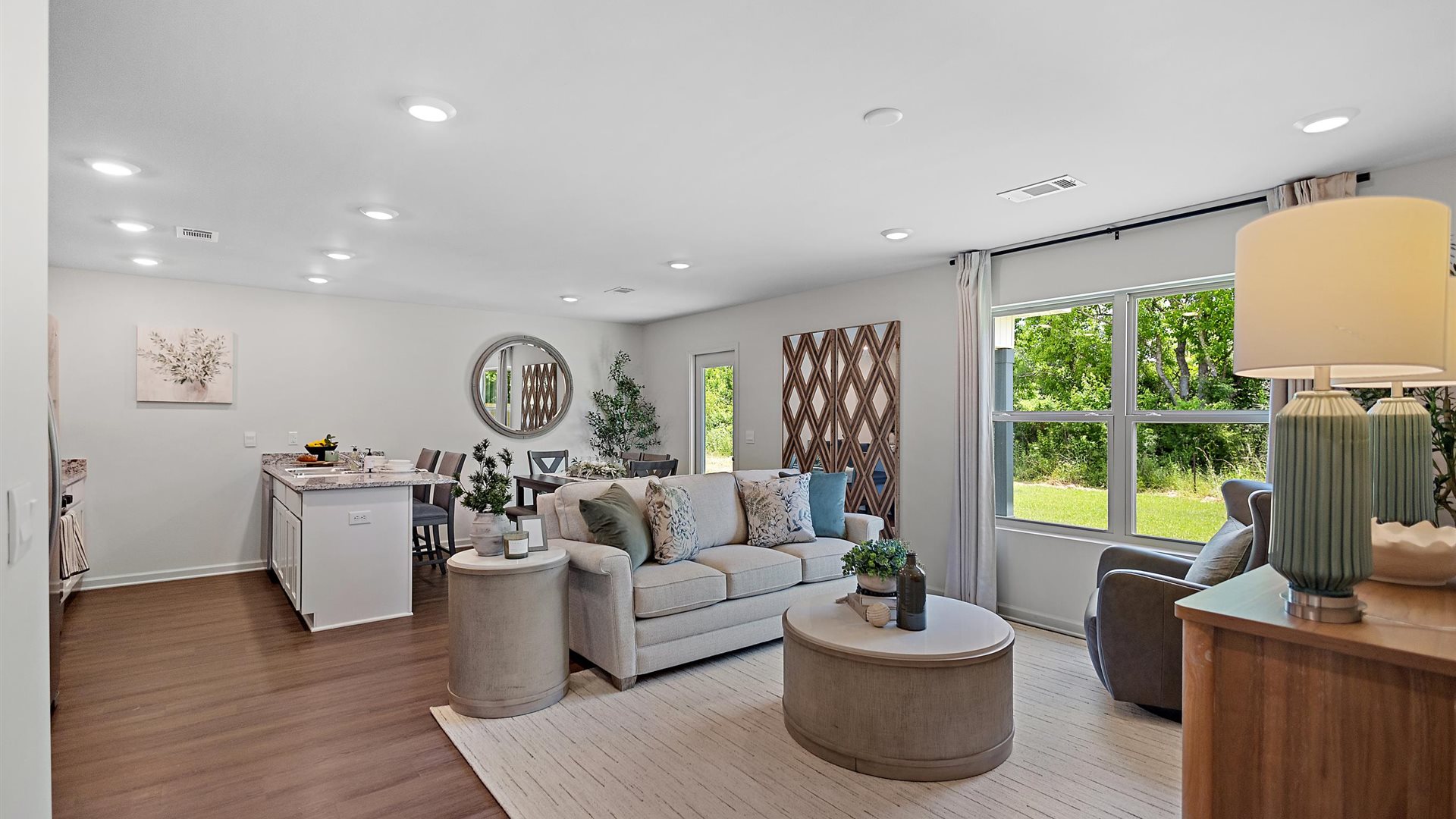 cozy living room with a beige sofa, neutral accent chairs and pops of blue decor
