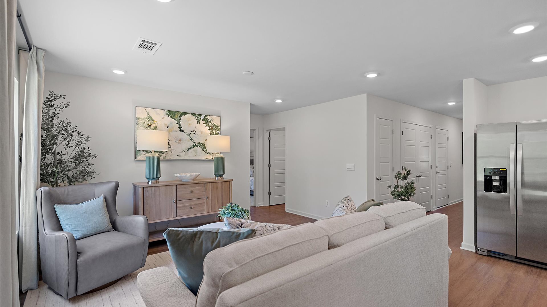 cozy living room with a beige sofa, neutral accent chairs and pops of blue decor