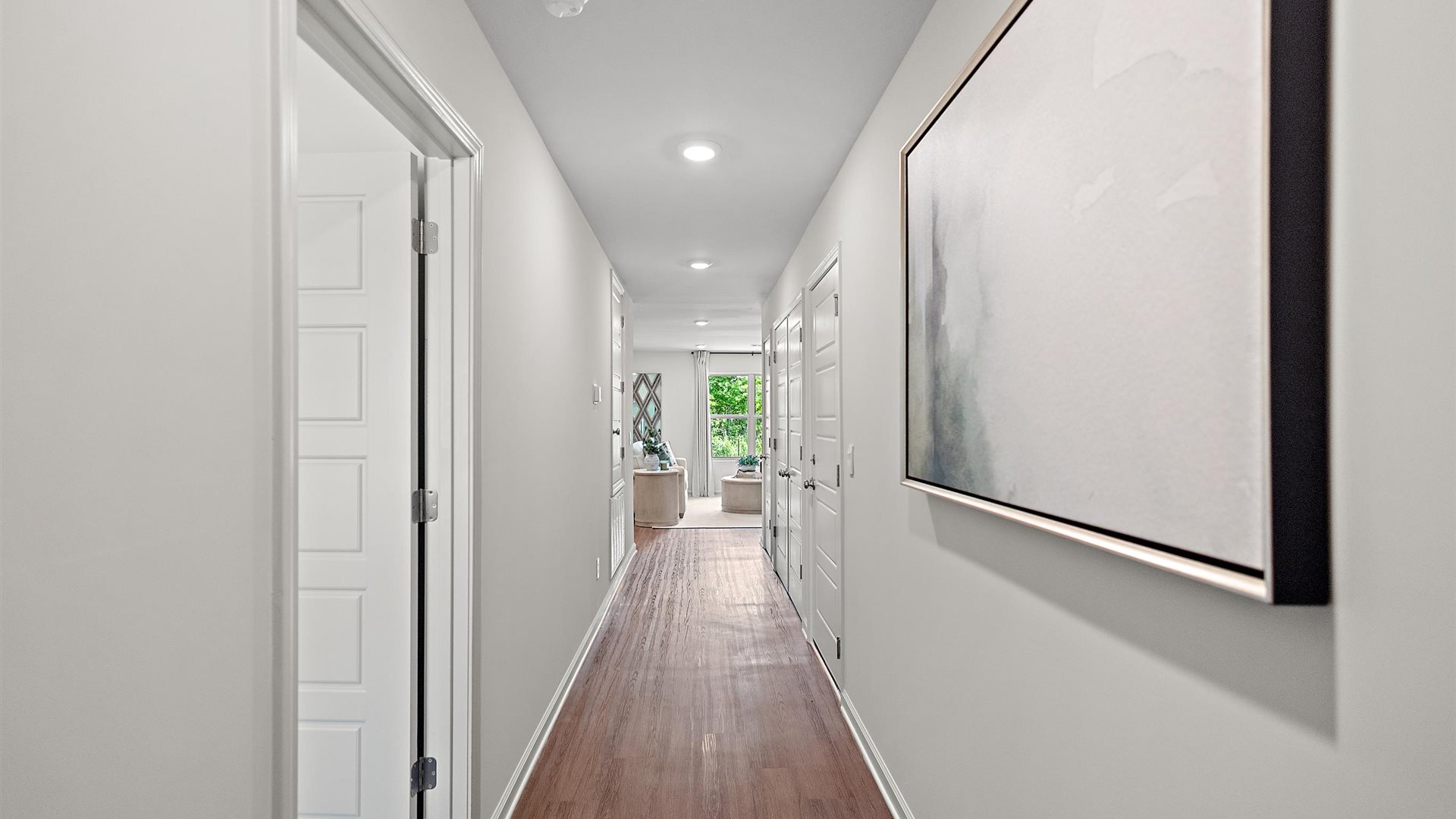 entry way hallway of home featuring brown flooring and a painting on the right