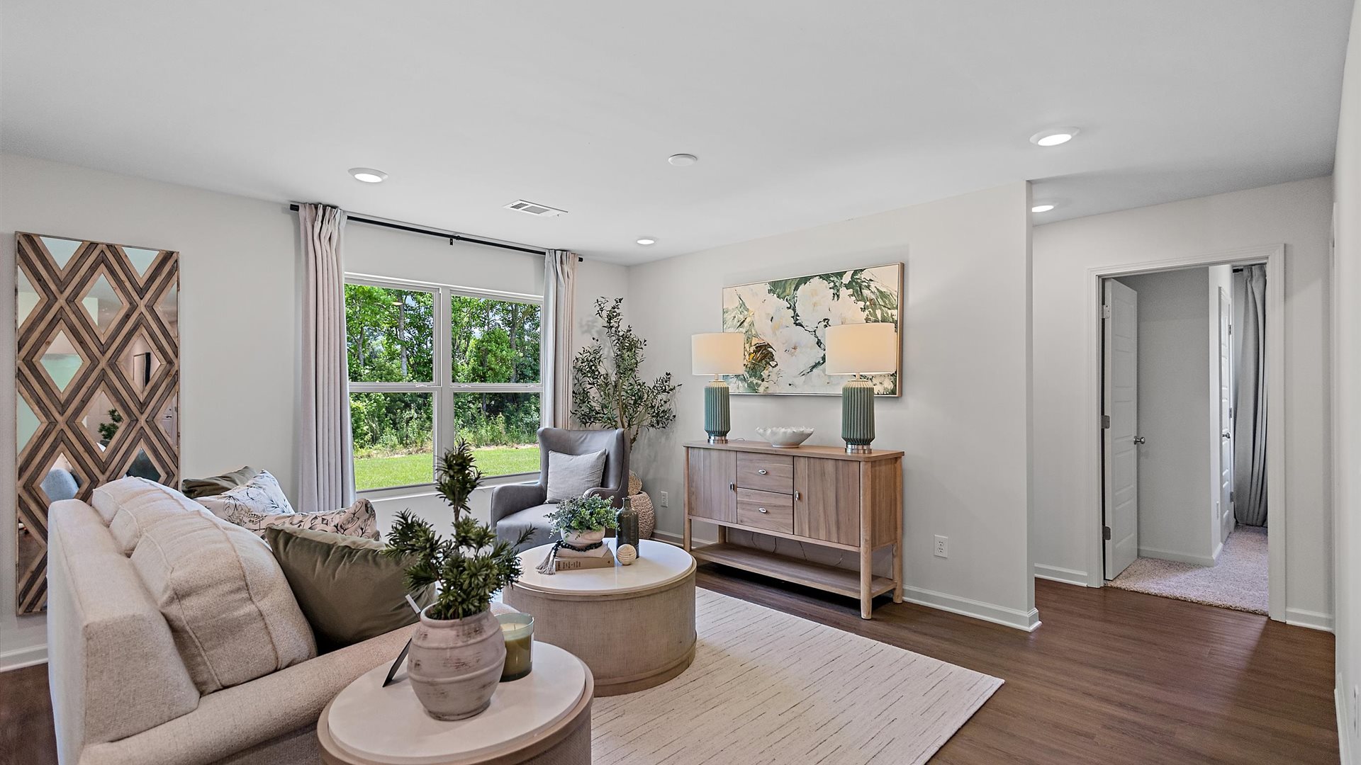 cozy living room with a beige sofa, neutral accent chairs and pops of blue decor
