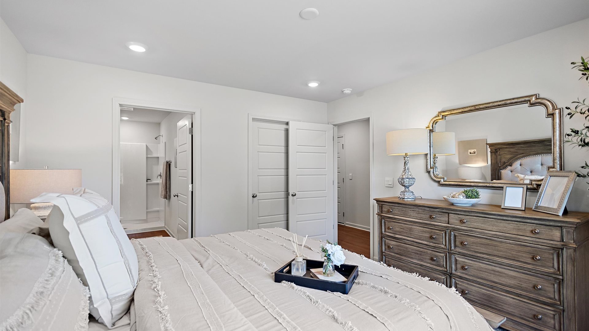 bedroom with a wooden bed, with beige bedding, and a large window