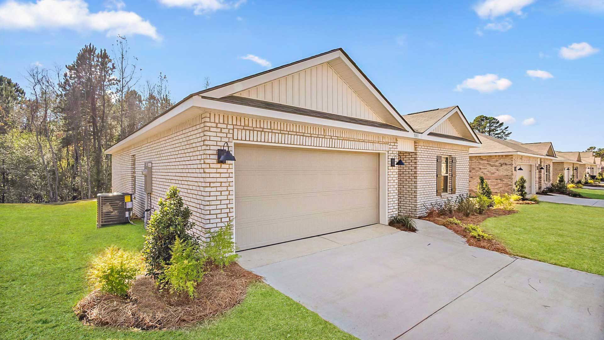 Other side exterior single story home with multi color brown brick and white paneling and brown shutters on the windows with side walk to the front door. The two-car garage and driveway.