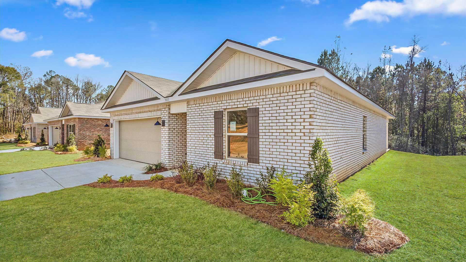 Other side exterior single story home with multi color brown brick and white paneling and brown shutters on the windows with side walk to the front door. The two-car garage and driveway.