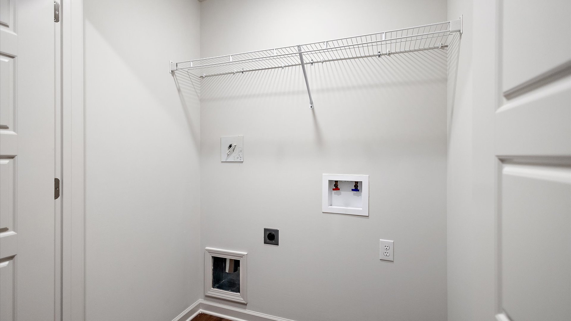 Laundry space with wire shelving and washer and dryer connections