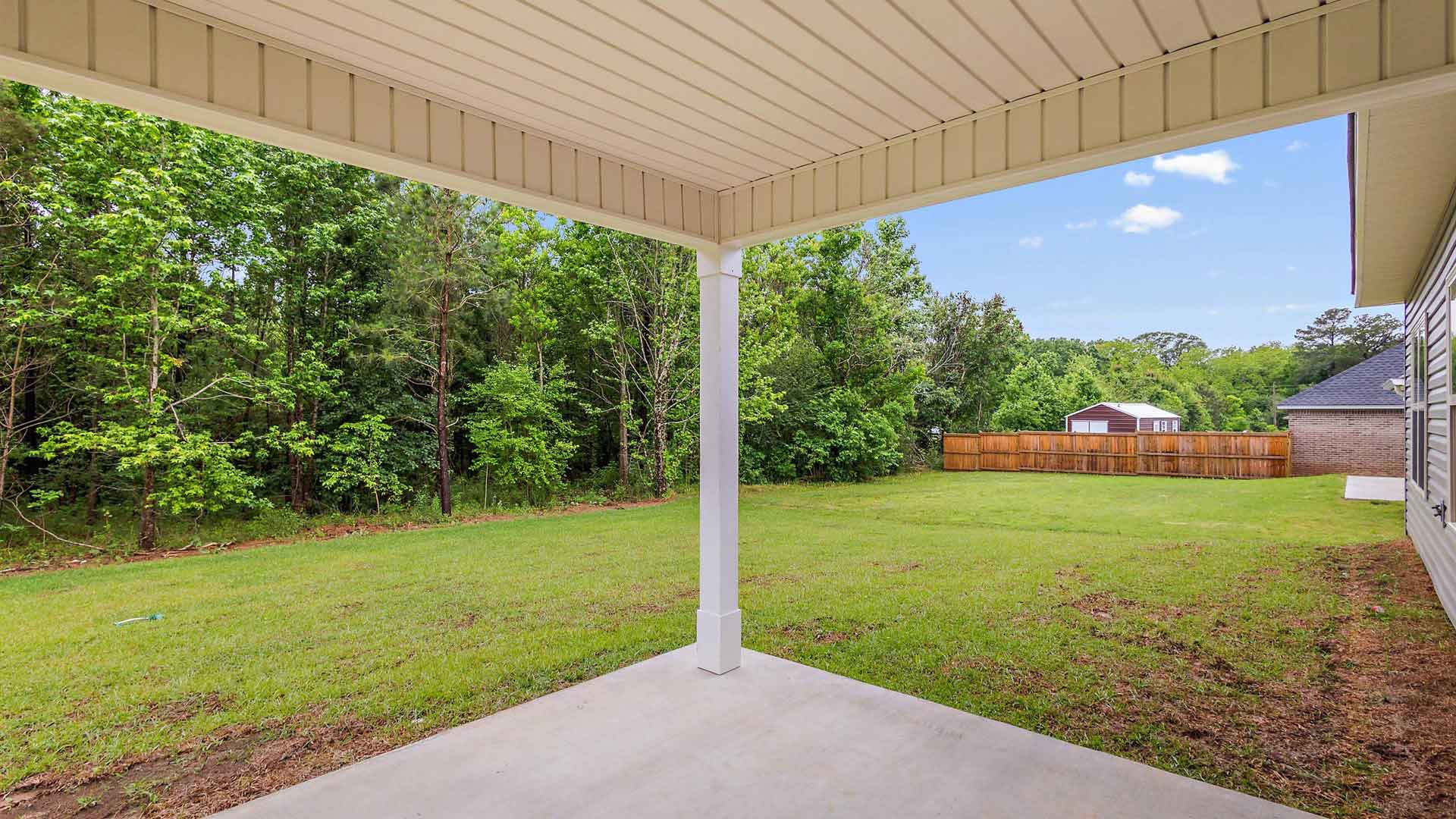 The covered back patio opens to greenspace.
