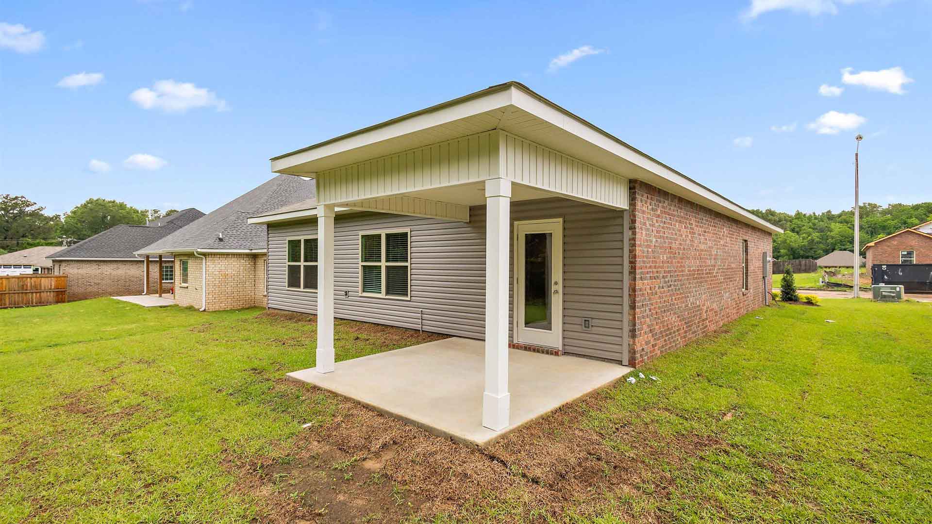 Back exterior of the other side of the house and the covered patio opening up the backyard.
