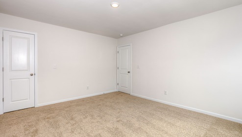 Carpeted bedroom with view of entrance door