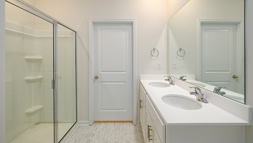bathroom with glass door shower and white counters