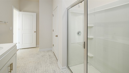 bathroom with glass door shower and white counters