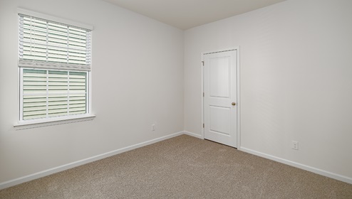 carpeted bedroom with one small window