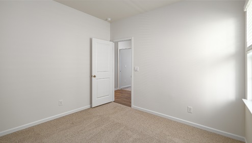 carpeted bedroom view of entry door