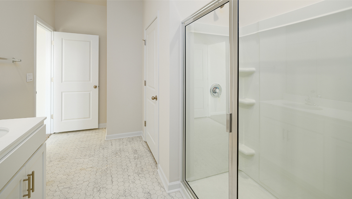 bathroom with glass door shower and white counters
