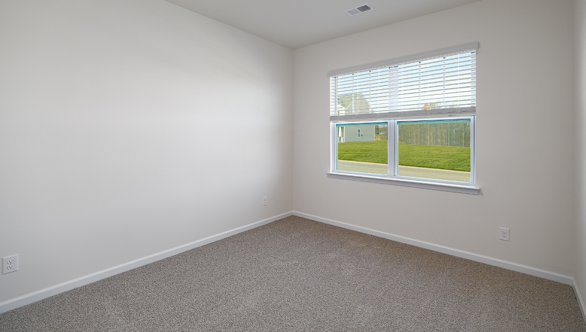 carpeted bedroom with one large window