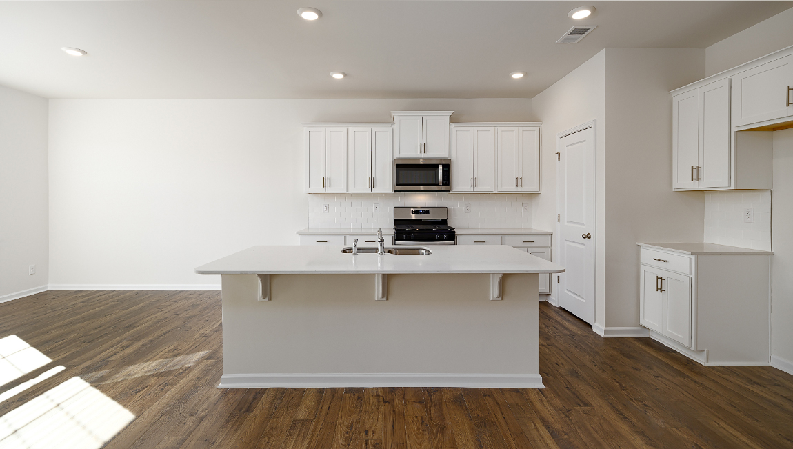kitchen with island, white counters and cabinets, and stainless steel appliances