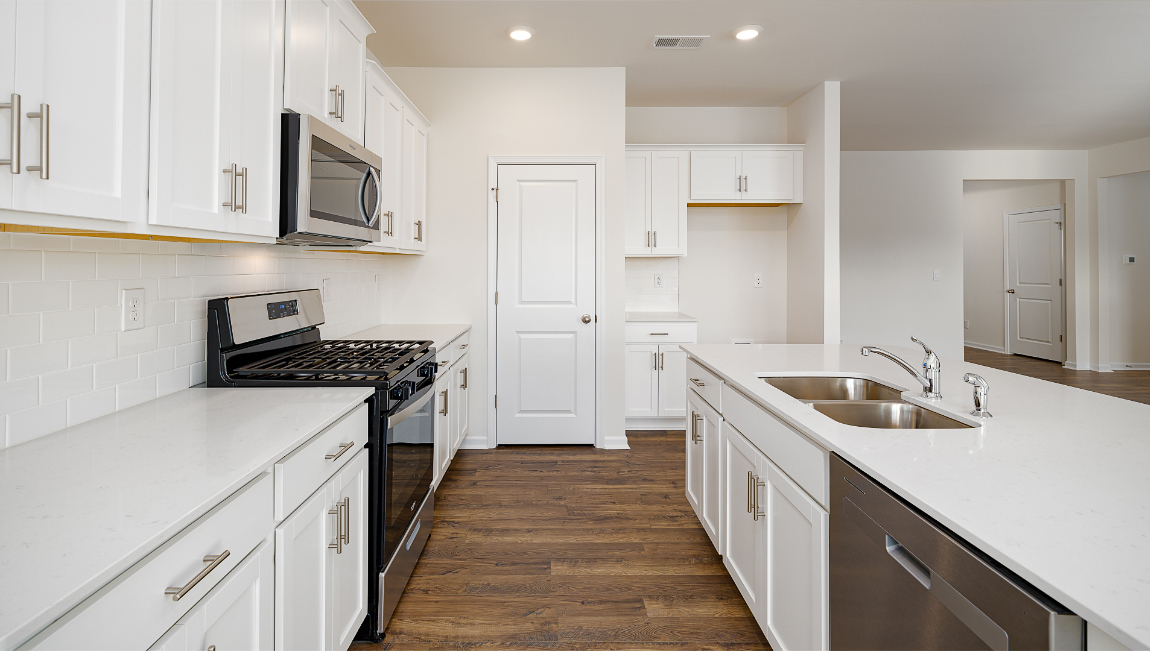 kitchen with island, white counters and cabinets, and stainless steel appliances
