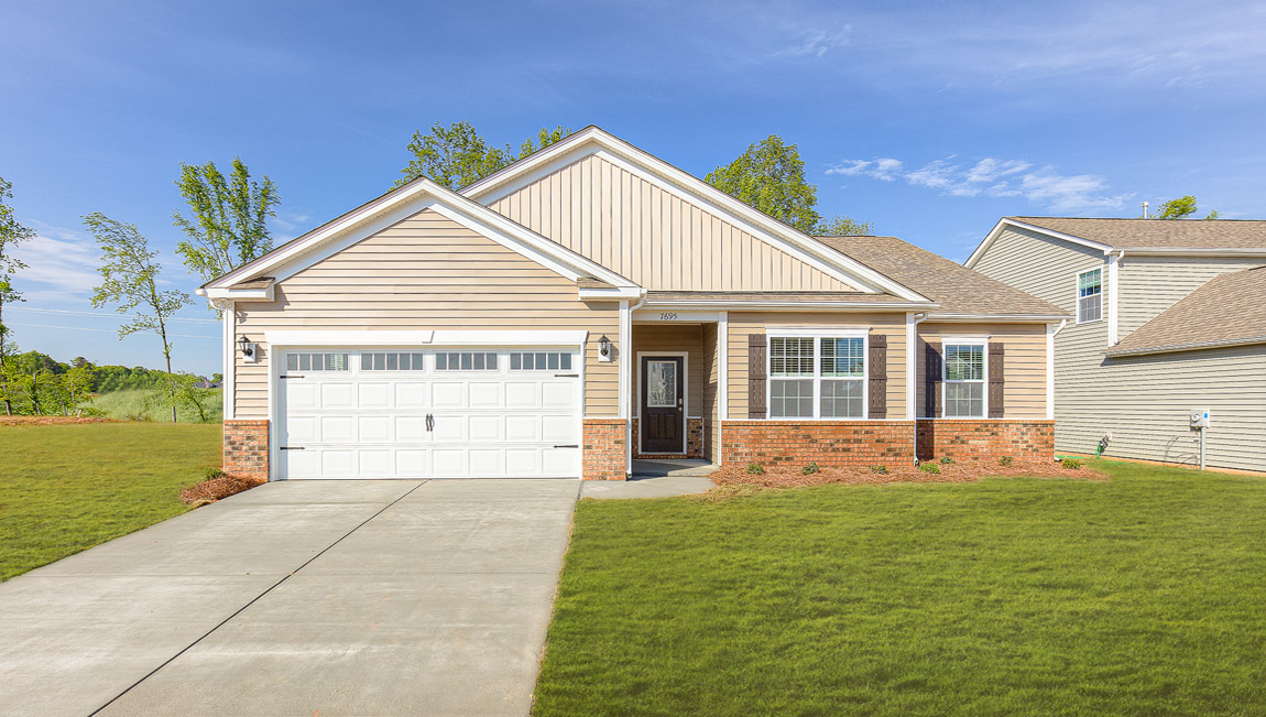 Booth front exterior with cream siding, brick and garage