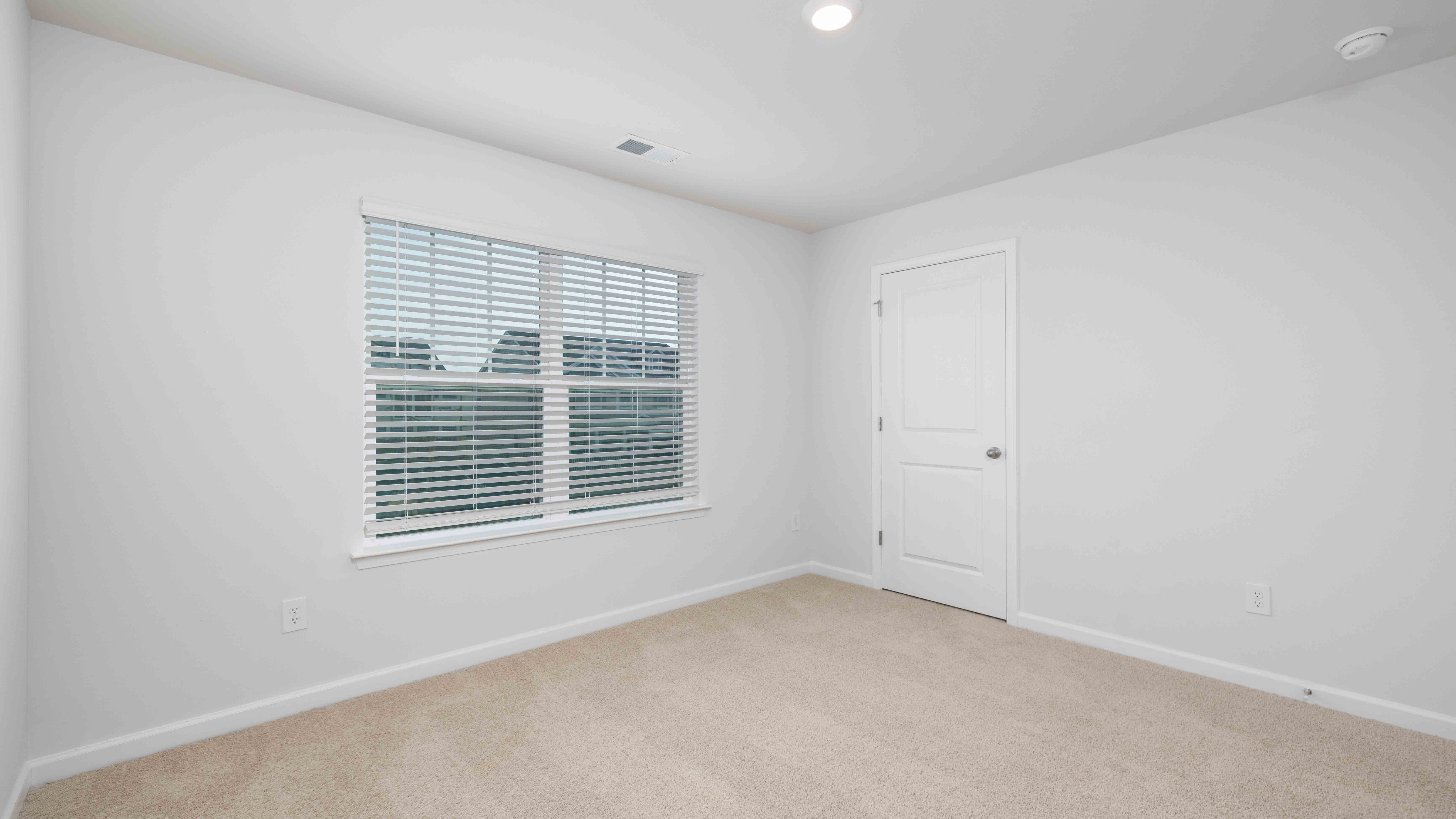 Carpeted bedroom with large window
