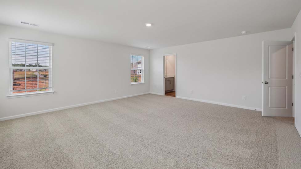 Carpeted bedroom with windows