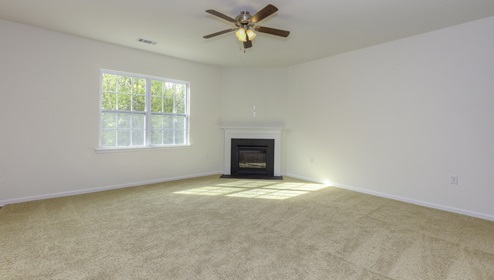 Family room with carpet, large window, and fireplace