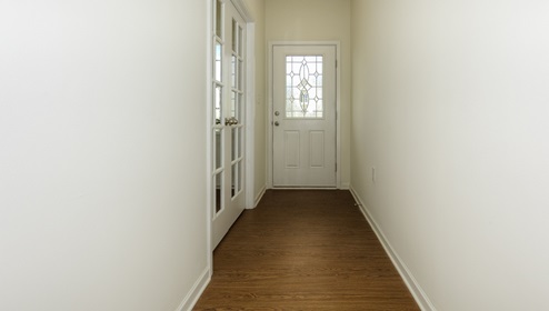Welcoming foyer with view of front door and office french doors