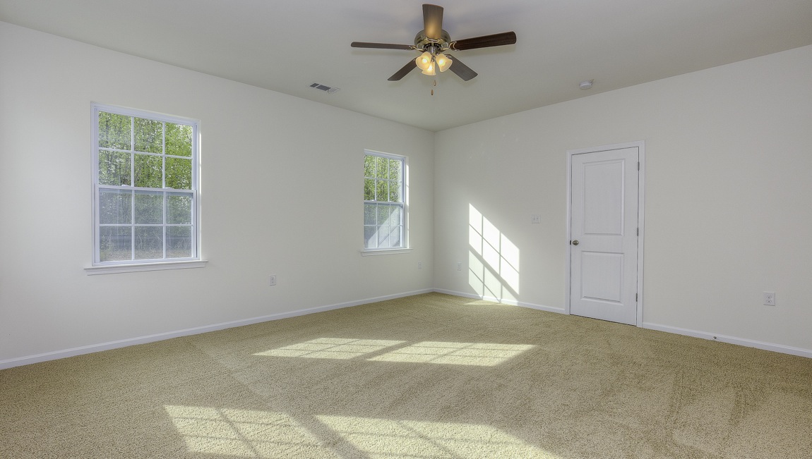 Primary bedroom with carpet, and three large windows