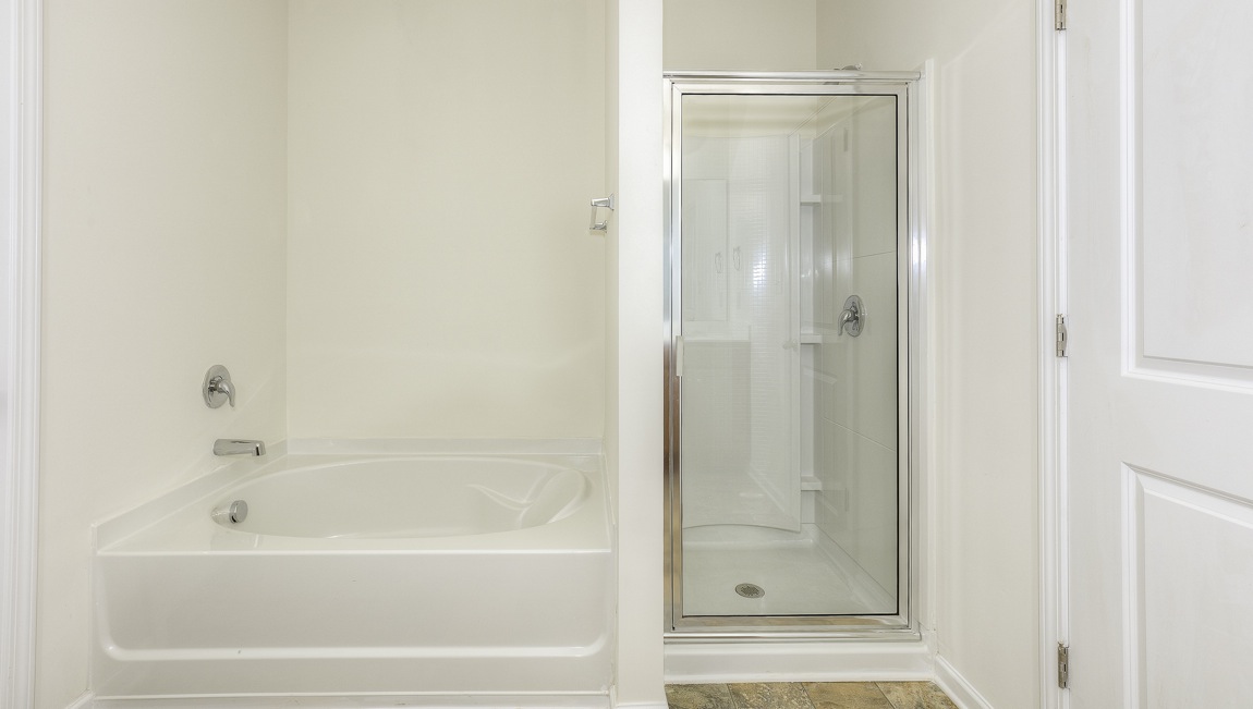 Primary bathroom with bathtub and glass door shower combination