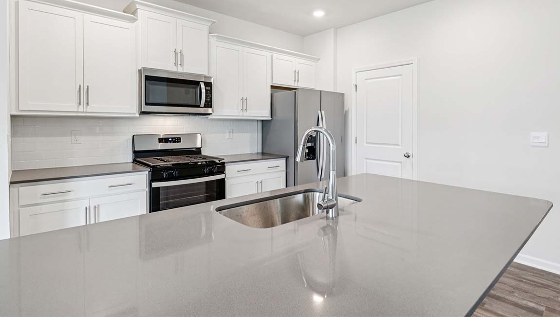 Kitchen and island with white cabinets, breakfast area at island, and stainless steel appliances