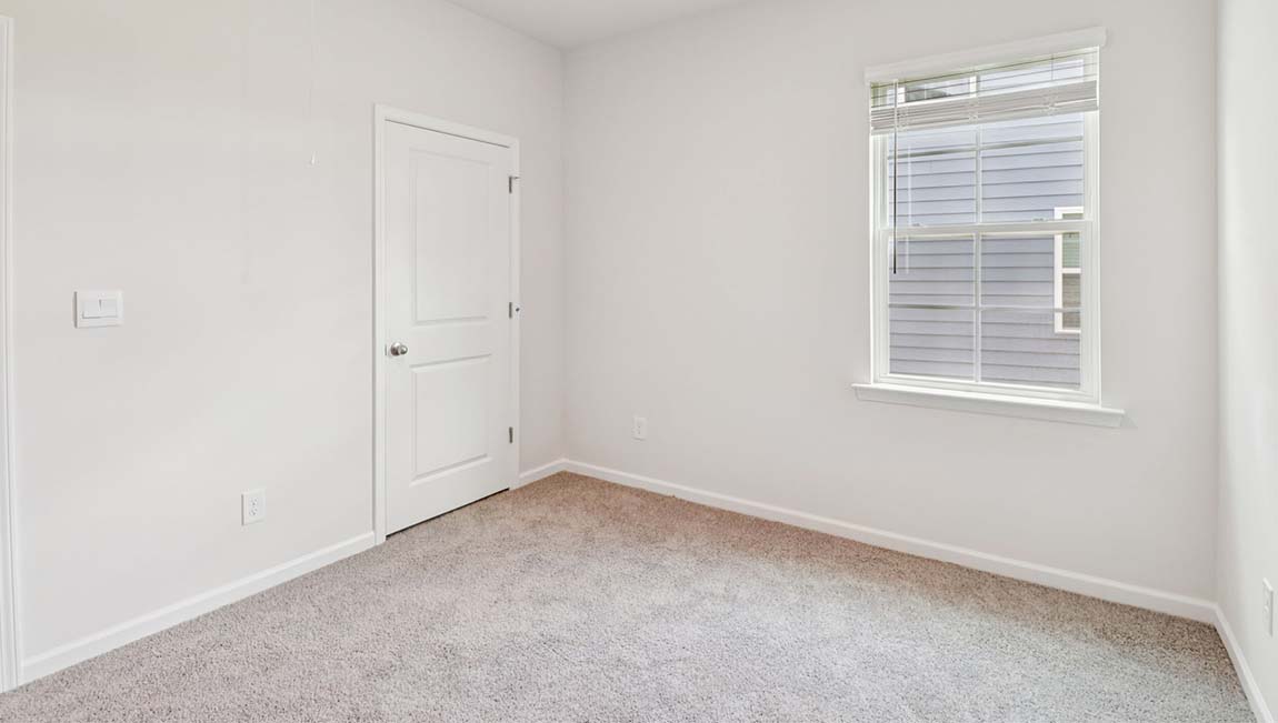 Carpeted bedroom with large window