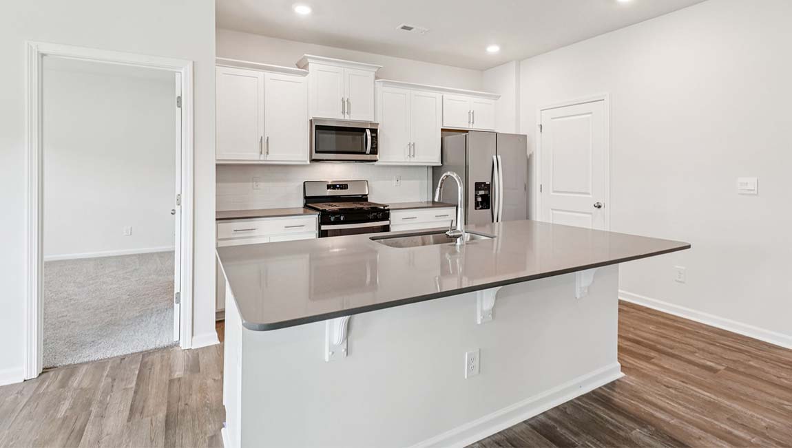 Kitchen and island with white cabinets, breakfast area at island, and stainless steel appliances