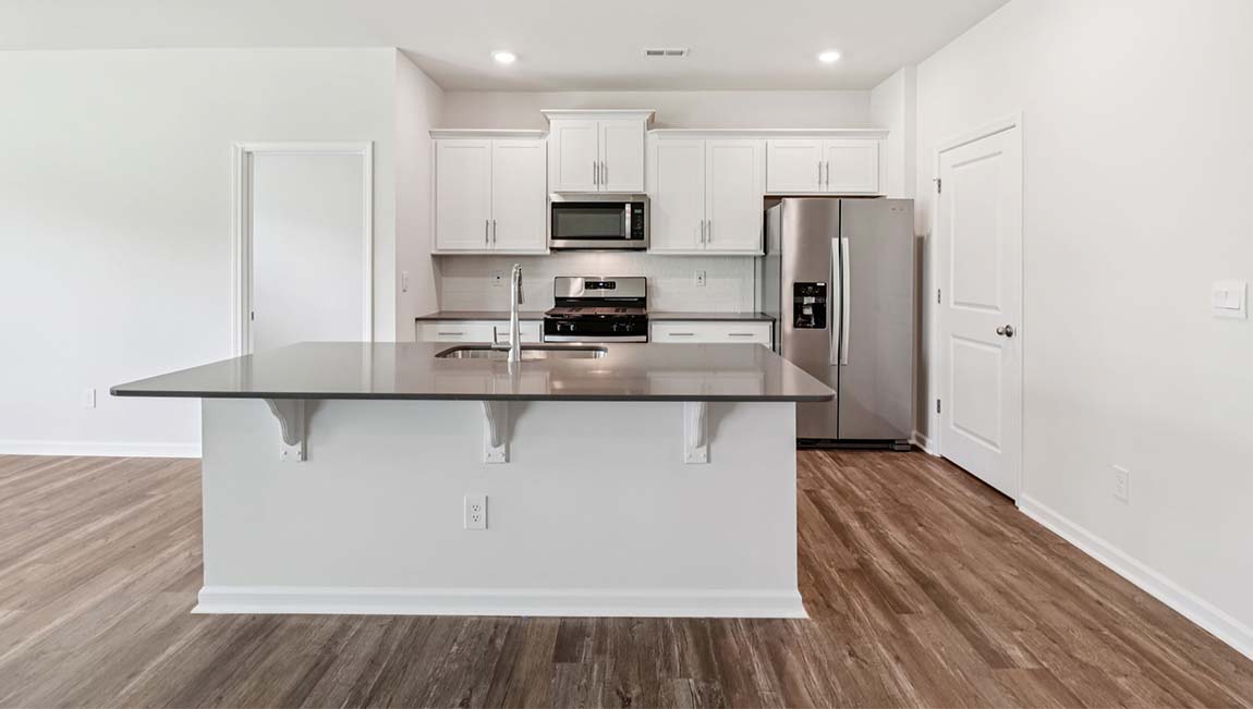 Kitchen and island with white cabinets, breakfast area at island, and stainless steel appliances