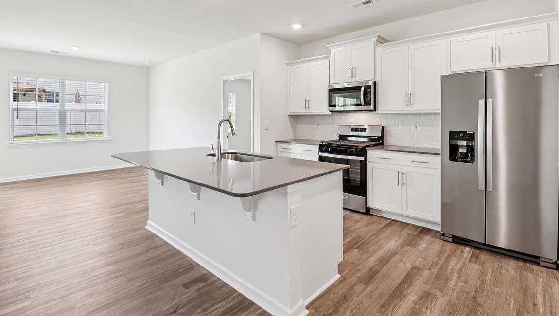 Kitchen and island with white cabinets, breakfast area at island, and stainless steel appliances