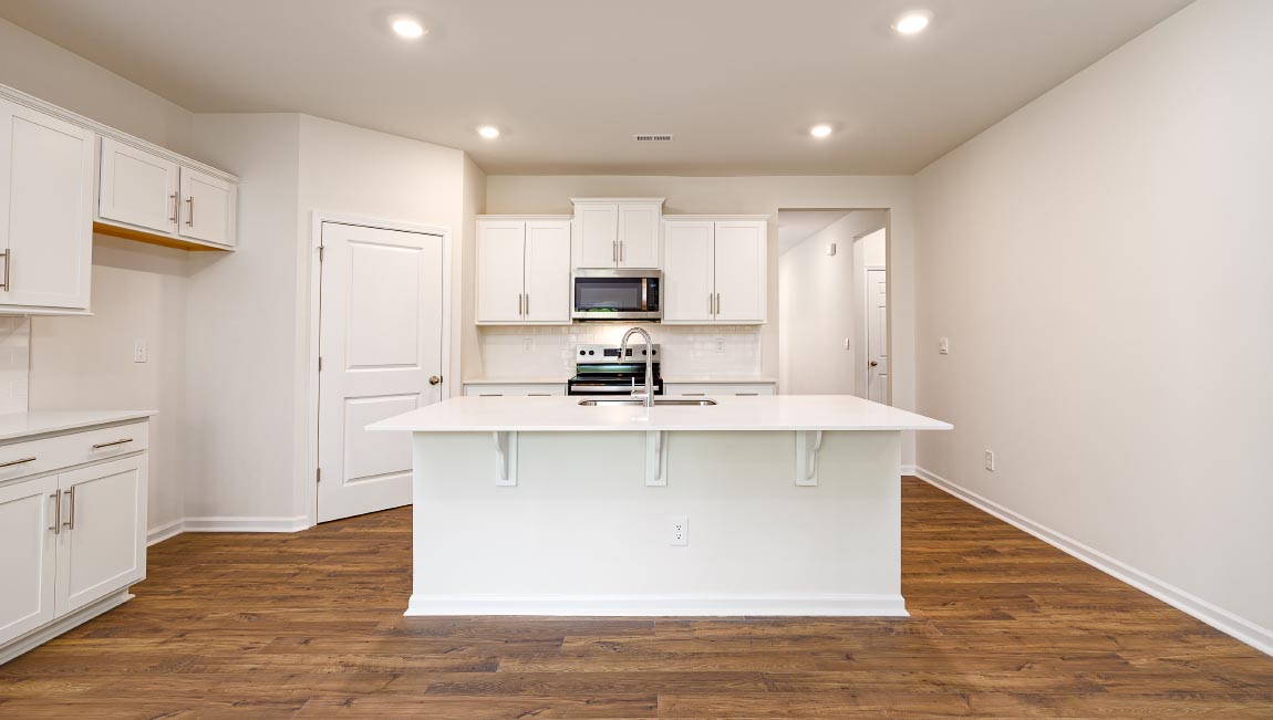 Kitchen and island with white cabinets, breakfast area at island, and stainless steel appliances