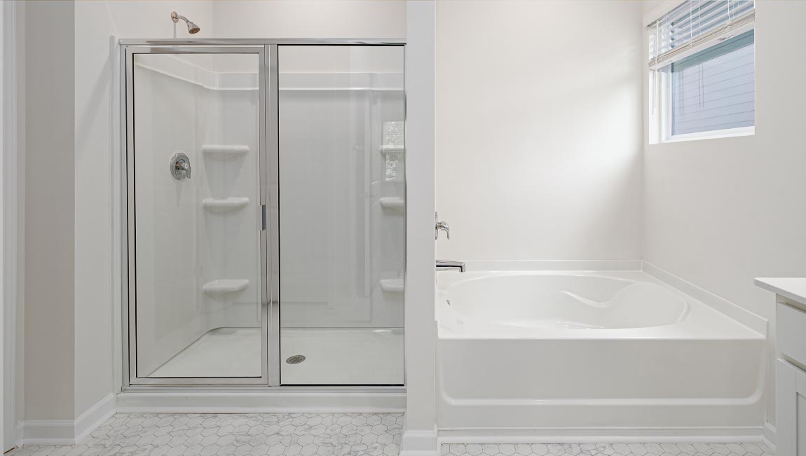 Bathroom with white cabinets and counters, double vanity, and glass door shower
