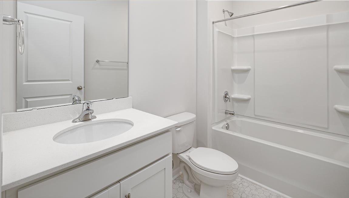 Bathroom with white cabinets and counters, double vanity, and glass door shower
