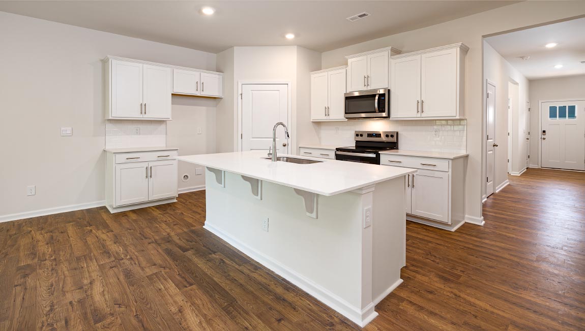 Kitchen and island with white cabinets, breakfast area at island, and stainless steel appliances