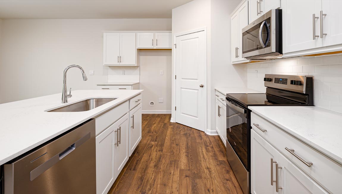 Kitchen and island with white cabinets, breakfast area at island, and stainless steel appliances