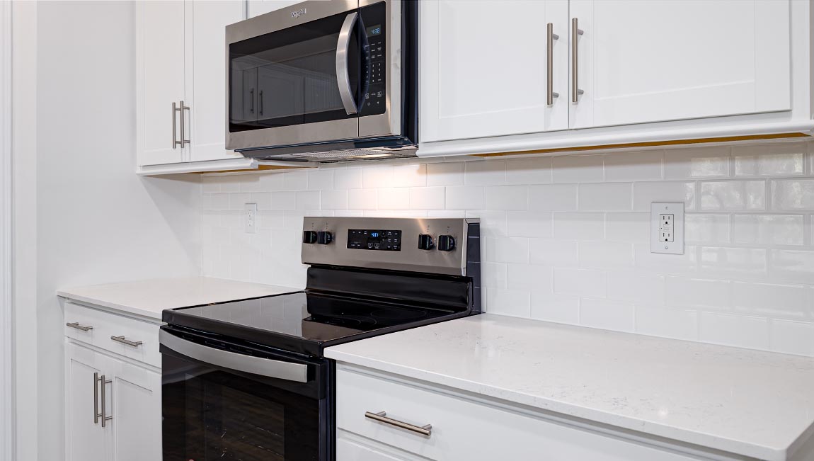 Kitchen and island with white cabinets, breakfast area at island, and stainless steel appliances