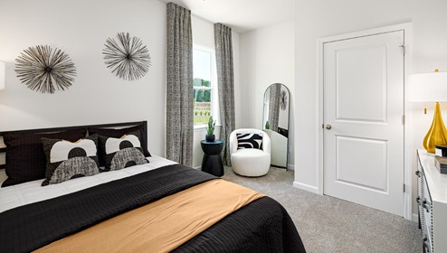 Carpeted bedroom with small window. New Home in Charlotte, North Carolina